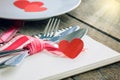 Valentines day table setting with plate, knife, fork, red ribbon Royalty Free Stock Photo