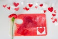 Valentines Day or wedding, invitation, scattered painted small cut out red, pink and white hearts with a red carnation