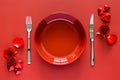 Valentines dining concept with red plate, fork and knife put on red table Royalty Free Stock Photo