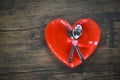 Valentines dinner romantic love concept Romantic table setting decorated with fork spoon in red heart plate on wooden Royalty Free Stock Photo