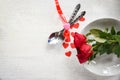 Valentines dinner romantic love concept Romantic table setting decorated with fork spoon red heart and roses on plate Royalty Free Stock Photo