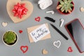 Valentines gift and BE MY VALENTINE card near hearts, succulent plants, earphones and smartphone