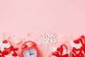 Flat lay photo of gift boxes with ribbon, heart shaped candles, alarm clock, inscription love you Royalty Free Stock Photo