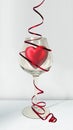 Valentines red heart in wine glass with ribbon