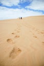 A couple hiking a sand dune