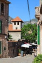 A narrow street in the town of Valldemossa with cafes, stone walls of houses and Windows with green