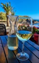 Valle Gran Rey - A glass and a carafe of white wine on a wooden table near beach Playa Charco del Conde, La Gomera