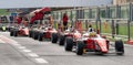 Front view of many racing single seater formula cars aligned in motorsport