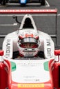 Front view portrait of formula car racing driver in cockpit with helmet