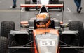 Front view portrait of formula car racing driver in cockpit with helmet