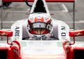 Front view portrait of formula car racing driver in cockpit with helmet