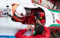 High angle view of team people talking with driver in cockpit racing