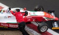 Team people pushing racing formula car in pit lane high angle view close up