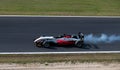 Formula racing car hard braking with smoke from tire