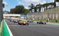 Race starting grid with aligned formula cars on straight racetrack