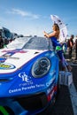 Beautiful grid girl posing with racing car