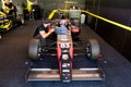 Driver in monoposto car talking with team technical manager with computer about the