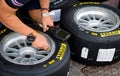 Mechanic checking pressure gauge in Pirelli racing tire close up