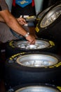 Mechanic checking pressure gauge in Pirelli racing tire close up