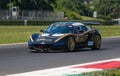 Lotus Exige model supercar racing car in action on asphalt track during the race