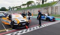 Mini Cooper cars racing starting grid first row pole position with team people before