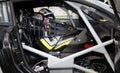 Touring car driver with helmet and suit sitting in cockpit looking at Royalty Free Stock Photo