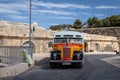 A vintage orange maltese bus parked in downtown street, Valletta, Malta. Royalty Free Stock Photo