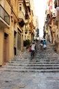 Valletta, Malta, August 2015. The old street of the city, stairs, climbing the mountain and the people on it.