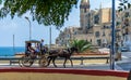 Vintage horse carriage couching tourists along embankment street in Valletta Royalty Free Stock Photo