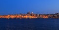 Valletta, Malta in the evening. Panoramic view of illuminated historic island and the dome of Carmelite Church and St Paul`s tower