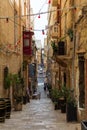 Typical Valletta street architecture with traditional Maltese wooden enclosed balconies and rising road, bulbs and potted plants s Royalty Free Stock Photo