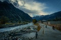 Valley with a crossing river in a residential area, people in the street in a village in Pakistan