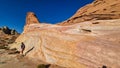 Valley of Fire - Woman climbing striated red and white rock formations along the White Domes Hiking Trail in Valley, Nevada, USA Royalty Free Stock Photo