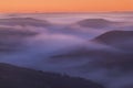 The valley is flooded in mist in a mountain environment. Over the fogs, only the high peaks of the mountains rise beneath Royalty Free Stock Photo