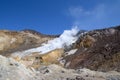 A valley of fumaroles with an eruption of water vapor and sulfur