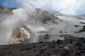 A valley of fumaroles with an eruption of water vapor and sulfur.