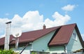 Valley and gable roofing construction with attic windows, rain gutter, waterproofing. Roof attic house metal tiles roofing with