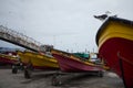 Fishing motor boats standing on carriages in the port. Seagull sits on the bow of the vessel.