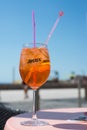 Aperol Spritz in glass on restaurant terrace in front of the beach