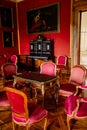 Valtice, Southern Moravia, Czech Republic, 04 July 2021: Castle interior with baroque wooden carved furniture, red salon, inlaid