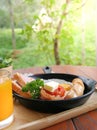 Value breakfast set, tomatoes wrapped in bacon, ham, eggs, sausage, salad and orange juice in the morning Royalty Free Stock Photo