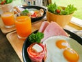 Value breakfast set, tomatoes wrapped in bacon, ham, eggs, sausage, salad and orange juice Royalty Free Stock Photo