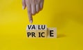 Value and Price symbol. Businessman Hand points at wooden cubes with words Price and Value. Beautiful yellow background. Business Royalty Free Stock Photo
