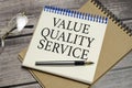 value quality service symbol on notepad and glasses and pen Royalty Free Stock Photo