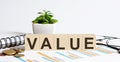 VALUE word on the wood blocks concept with chart, coins, notebook and glasses Royalty Free Stock Photo