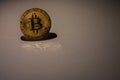 valueable golden bitcoin illuminated with shadow and reflection