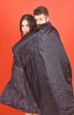 Vampire in cloak behind sexy devil girl. Man and woman dressed like vampire, demon, red background. Couple in love Royalty Free Stock Photo