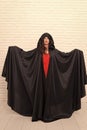 Vampire in cloak sexy devil girl. Woman tempting vampire demon. Girl covered with cloak. Devil concept. Halloween