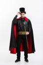 Vampire Halloween Concept - Full length Portrait of handsome caucasian Vampire in black and red halloween costume.