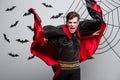 Vampire Halloween Concept - Portrait of handsome caucasian Vampire halloween costume fluttering his red, black cloak. Royalty Free Stock Photo